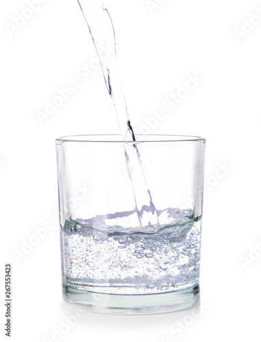 Pouring of fresh water into glass on white background