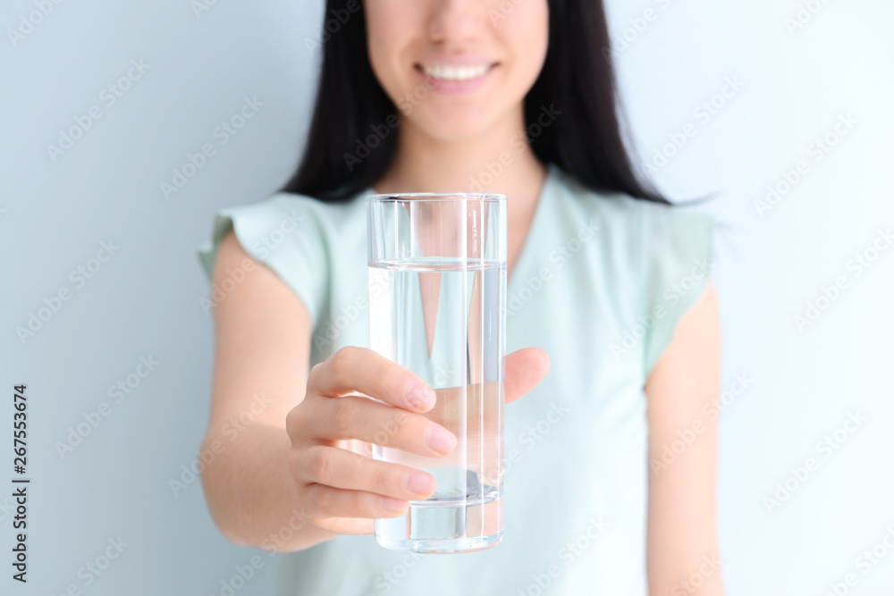 Woman with glass of fresh water on light background Woman with glass of fresh water on light background