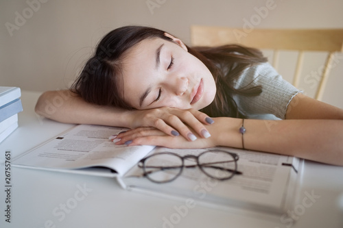 Obraz na plátně Cute teenager girl fell asleep on the books when she did her homework