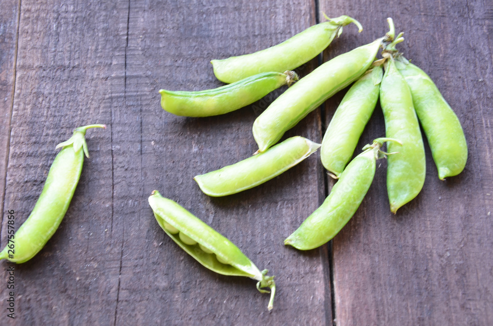 fresh green peas, just harvest. close up view of opened pod. spring vegetable up view on the wooden background fresh green peas, just harvest. close up view of opened pod. spring vegetable up view on the wooden background