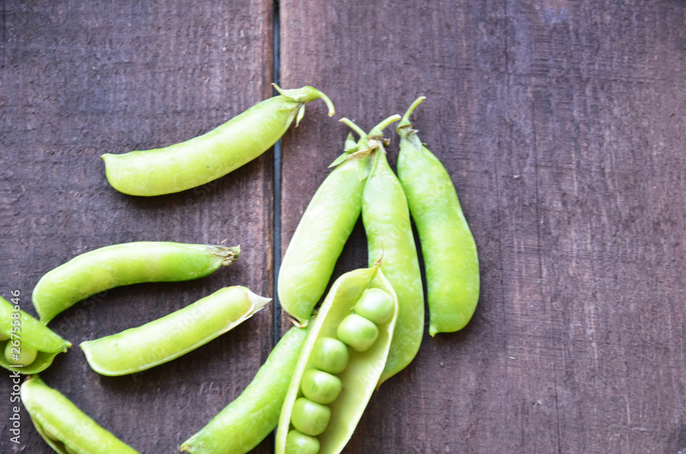 fresh green peas, just harvest. close up view of opened pod. spring vegetable up view on the wooden background fresh green peas, just harvest. close up view of opened pod. spring vegetable up view on the wooden background