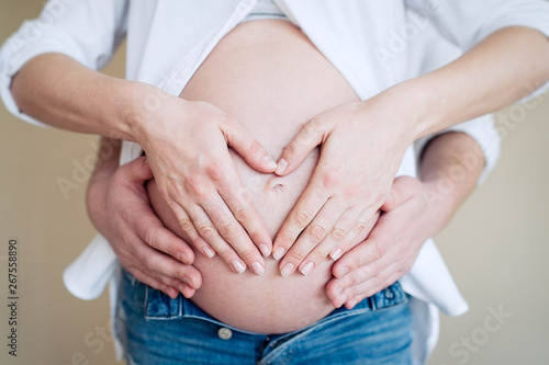 Wallpaper Mural Pregnant woman with her husband hugging tummy, heart symbol on belly. Concept of Pregnancy health care       Torontodigital.ca