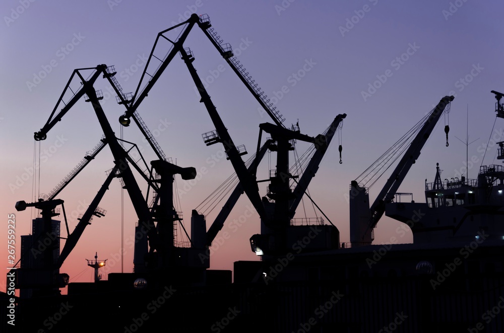 Silhouette of port cranes in the evening. port cranes at sunset Silhouette of port cranes in the evening. port cranes at sunset