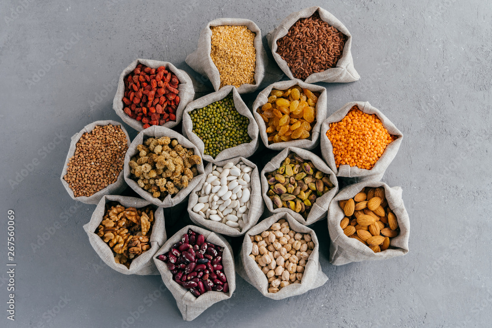 Top view of small bags with cereal grains: buckwheat, lentil, haricot, chickpea, goji, raisins, pistache, Chickasano pea, mulberry, sycamin, almond. Collection set Top view of small bags with cereal grains: buckwheat, lentil, haricot, chickpea, goji, raisins, pistache, Chickasano pea, mulberry, sycamin, almond. Collection set