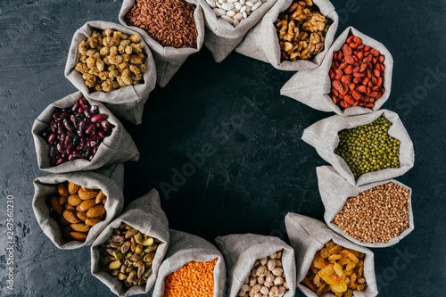 Food and nutrition concept. Horizontal shot of sacks filled with protein rich dried fruits and legumes. Almonds, walnuts, raisins, pink seeds. photo