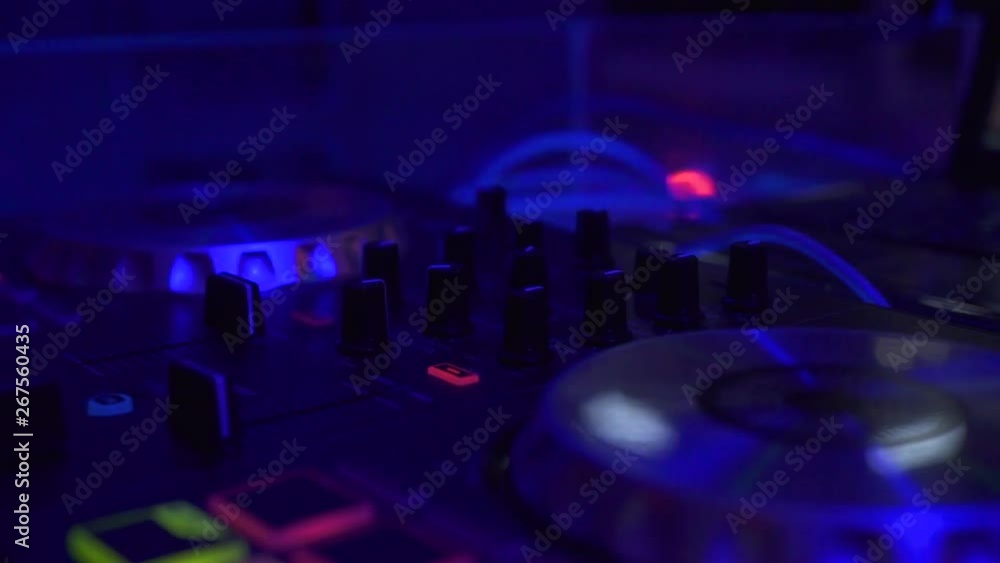 Professional dj equipment for mixing and record dance music o in night club. Close up musicequipment and DJ control console with colorful light in nightclub. Night life concept. Professional dj equipment for mixing and record dance music o in night club. Close up musicequipment and DJ control console with colorful light in nightclub. Night life concept.