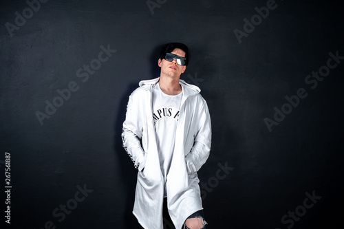 guy in black glasses on a dark background of concrete in the studio, positioning in the studio of a young guy in black glasses © александр таланцев