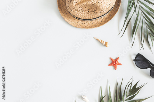 Summer composition. Tropical palm leaves, hat on gray background. Summer concept. Flat lay, top view, copy space