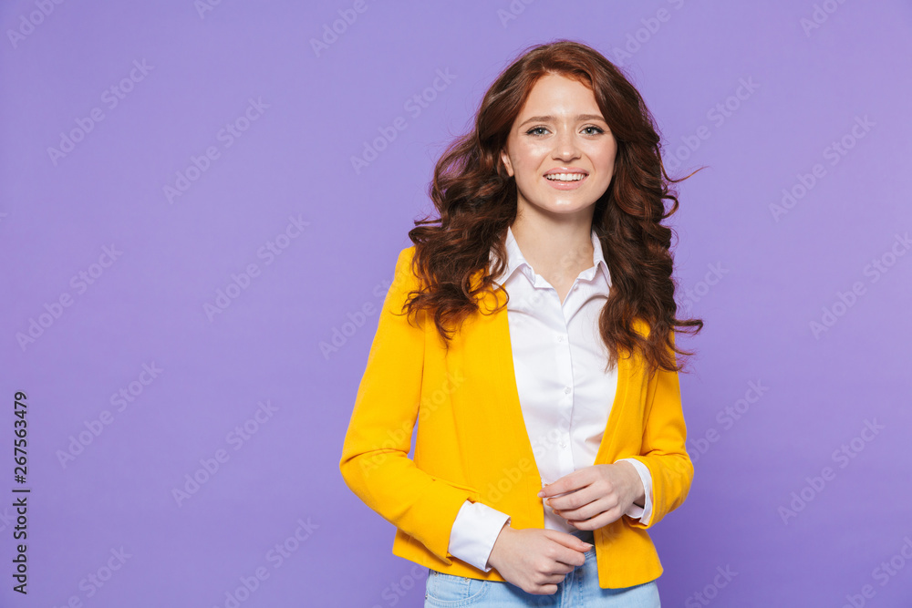 Image of gorgeous redhead woman wearing yellow jacket smiling and looking at camera Image of gorgeous redhead woman wearing yellow jacket smiling and looking at camera