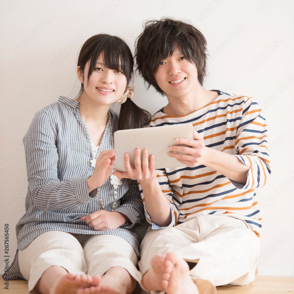 タブレットPCを持ち微笑むカップル タブレットPCを持ち微笑むカップル