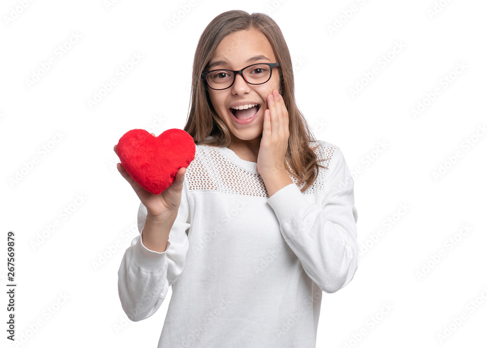 Happy Valentines Day. Surprised Cute young Teen Girl with Eyeglasses in Love with Red plush Heart in her hands. Shocked or surprised Child, isolated on white background. Happy Valentines Day. Surprised Cute young Teen Girl with Eyeglasses in Love with Red plush Heart in her hands. Shocked or surprised Child, isolated on white background.