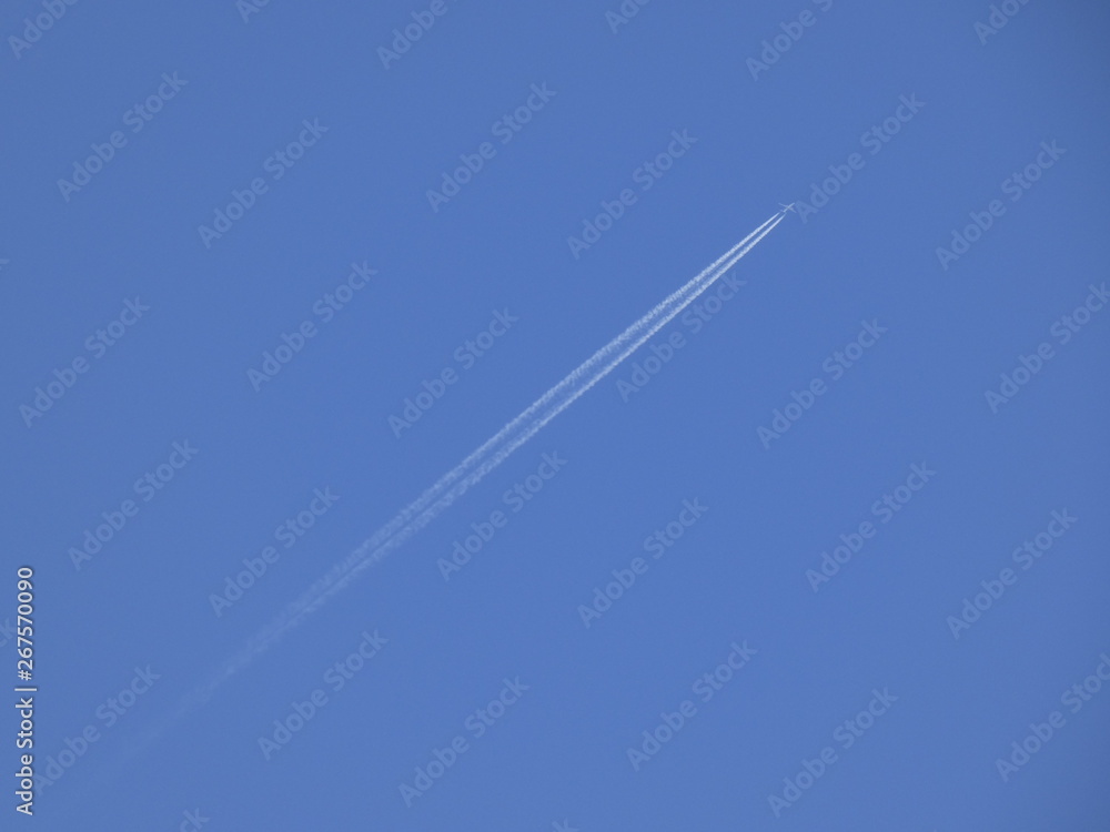 Avión surcando un cielo azul y dejando una estela blanca a su paso Avión surcando un cielo azul y dejando una estela blanca a su paso