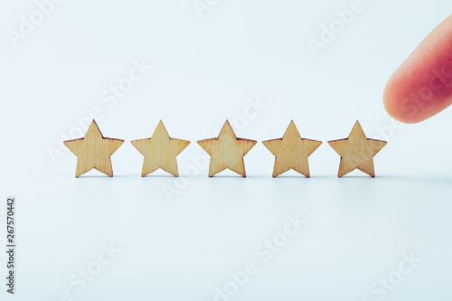 Hand pointing wooden five star shape on white background