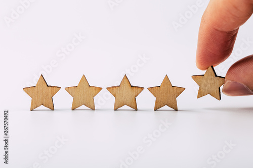 Hand putting wooden five star shape on white background