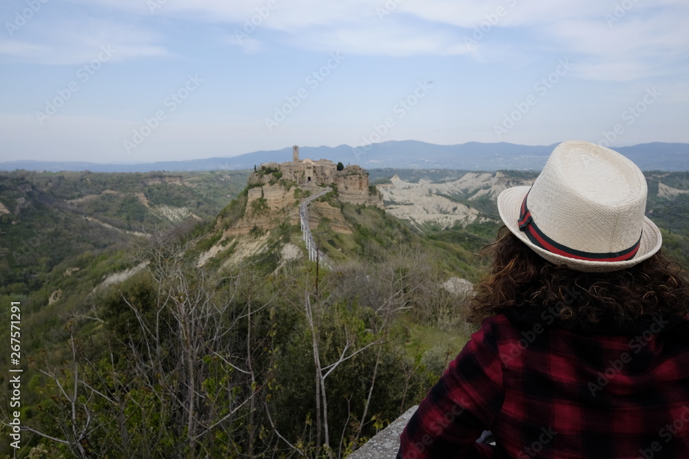Woman looks at Civita di Bagnoregio in the distance