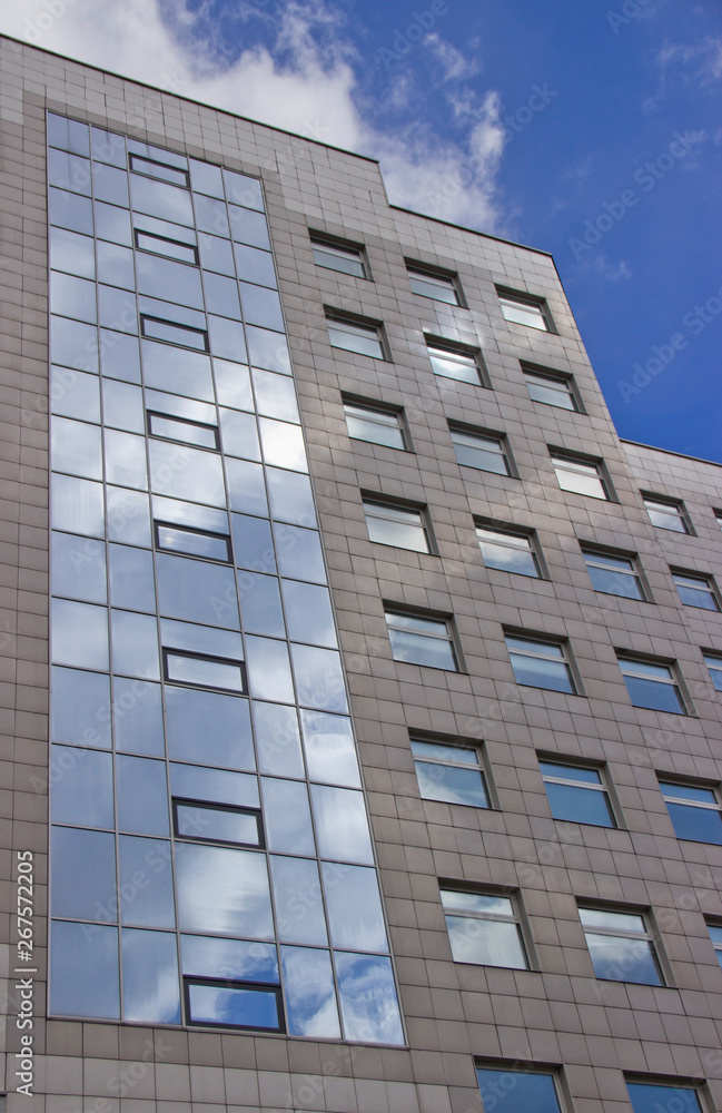 the facade of a high multi-storey building against the sky