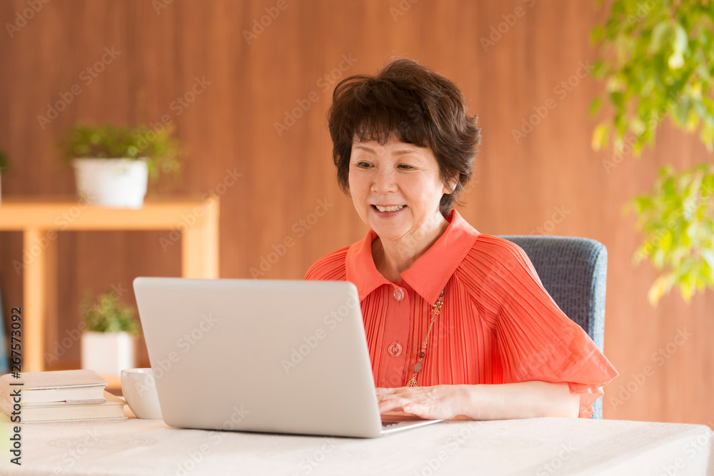ノートパソコンを操作するシニア女性