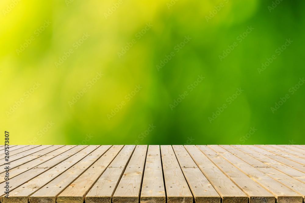 Empty wood plank table top with blur park green nature background Empty wood plank table top with blur park green nature background