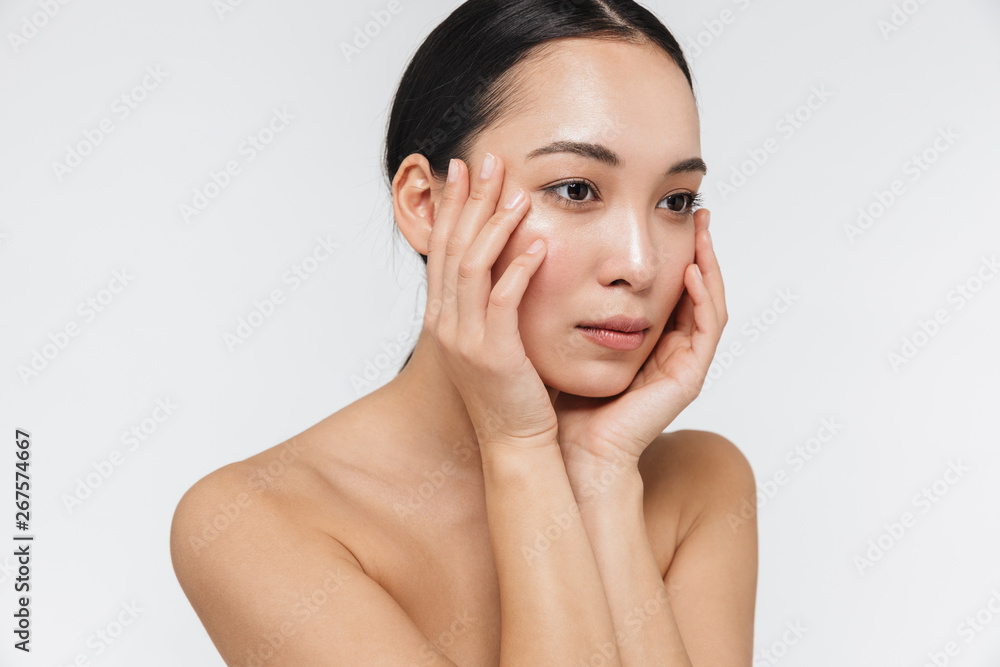 Asian woman posing naked isolated over white wall background. Asian woman posing naked isolated over white wall background.