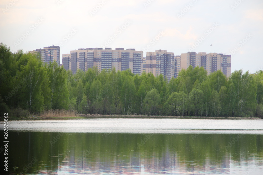 New building, many apartments at home. Residential building in a public green Park is located next to the lake