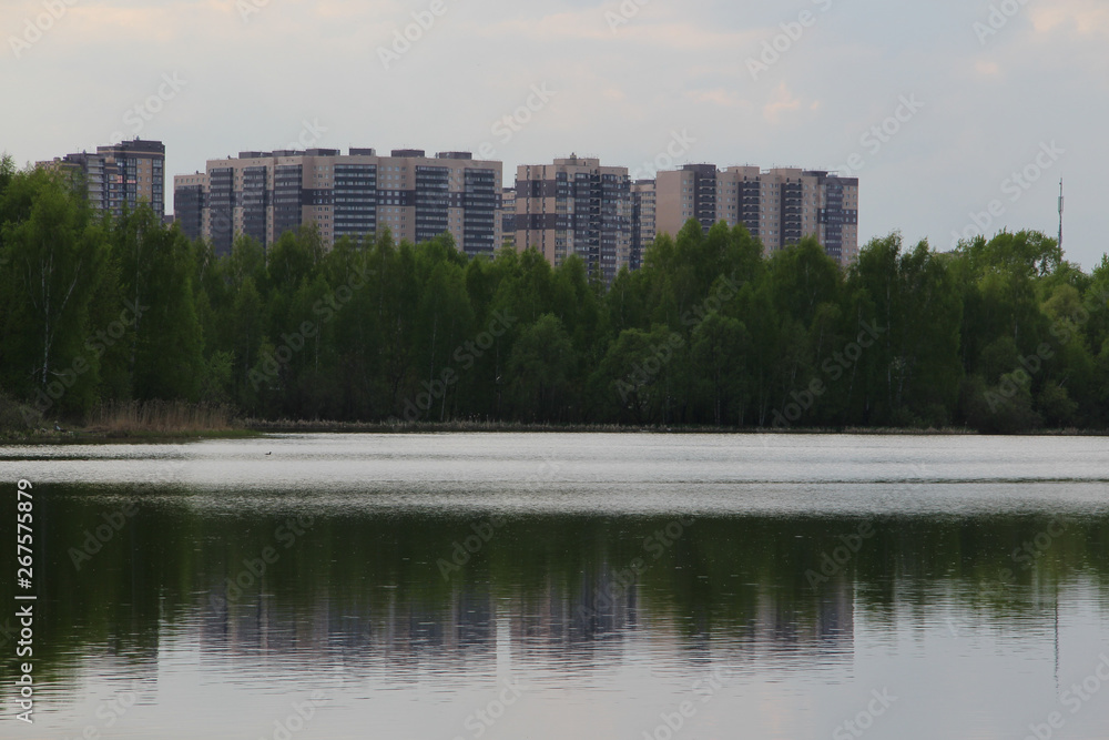 New building, many apartments at home. Residential building in a public green Park is located next to the lake New building, many apartments at home. Residential building in a public green Park is located next to the lake