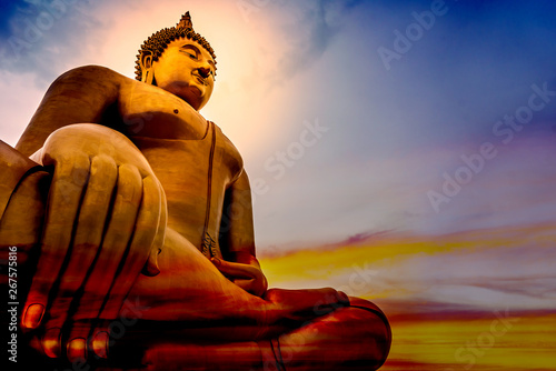 Cuadro en lienzo The large golden lord of Buddha statue that is faithful on a beautiful and colourful sky with orange, yellow, red, blue