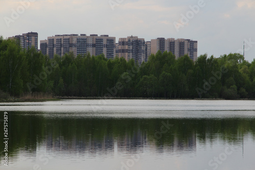 New building, many apartments at home. Residential building in a public green Park is located next to the lake