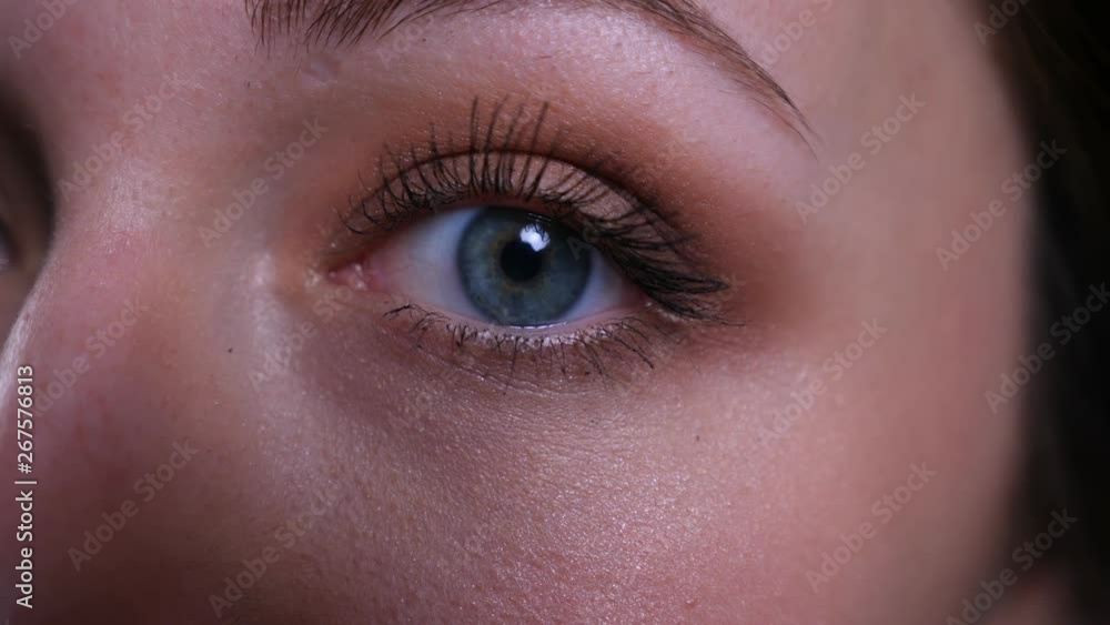 Closeup half face portrait of young pretty caucasian brunette female looking straight at camera Closeup half face portrait of young pretty caucasian brunette female looking straight at camera