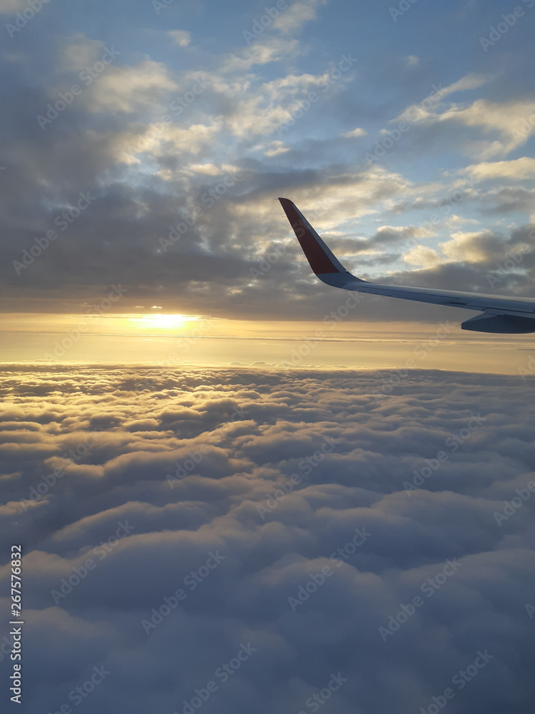 Obraz premium Beautiful sunset sky above clouds with dramatic light. Cabin view from airplane 