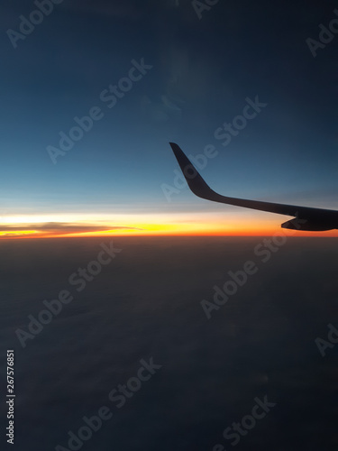 View from the wing of the aircraft in flight, the evening Golden light under the clouds.
