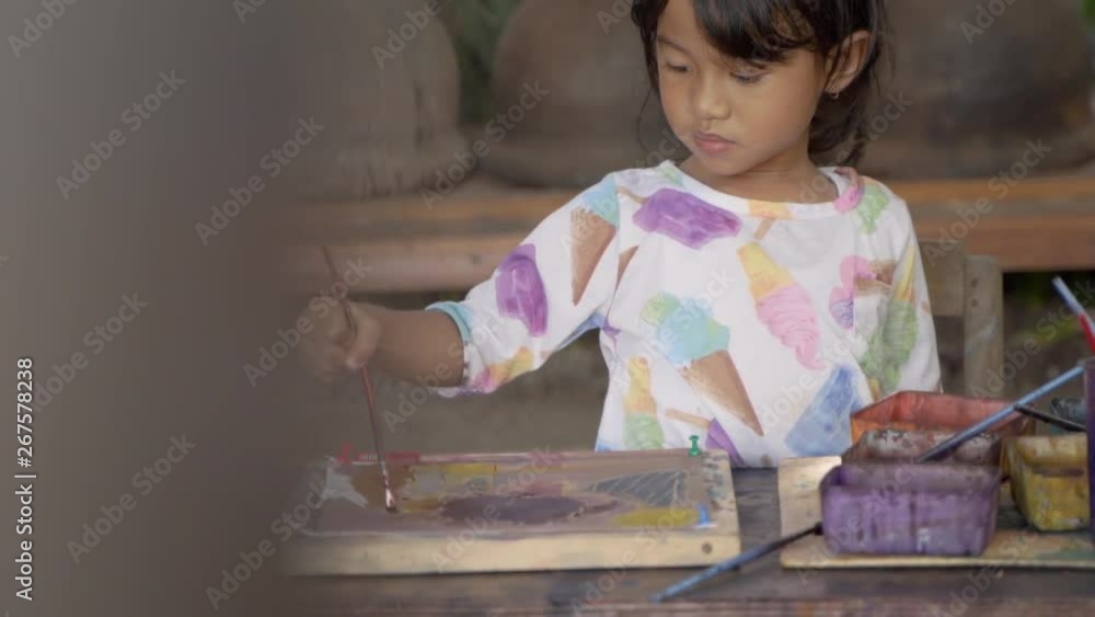 child painting on white fabric. asian kid learn to make batik child painting on white fabric. asian kid learn to make batik