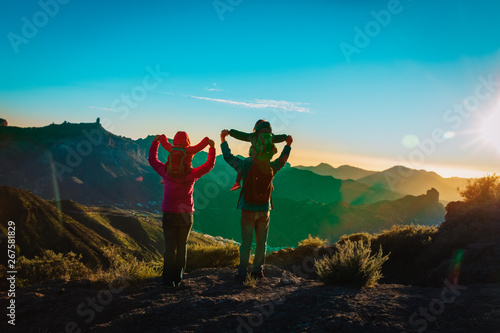 happy family with kids travel in mountains at sunset