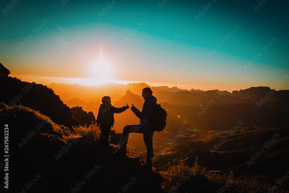 father and little daughter travel in mountains at sunset father and little daughter travel in mountains at sunset