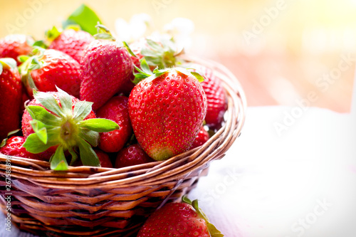Juicu strawberries in wicker basket closeup on table