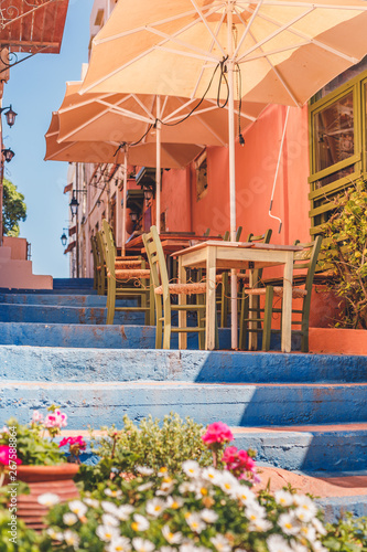 Tables and chairs outside on a stairway in a little coastal town near the sea