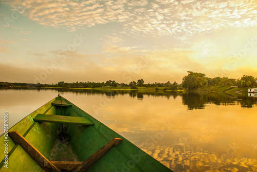 Beautiful sunrise on the river. View from the boat at Amazon river, with a dense forest on the shore and blue sky, Anazonas, Brazil