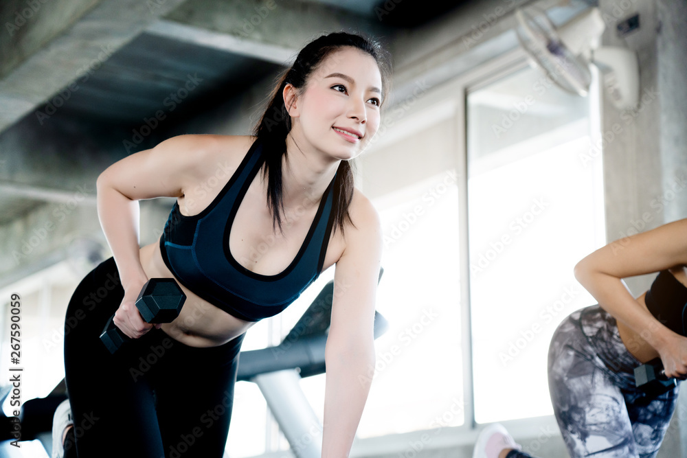 Concept of doing business, opening gym Asian women are exercising using dumbbells to reduce arms. Increase strength of muscles. Regular exercise will result in a balanced shape and good mental health. Concept of doing business, opening gym Asian women are exercising using dumbbells to reduce arms. Increase strength of muscles. Regular exercise will result in a balanced shape and good mental health.