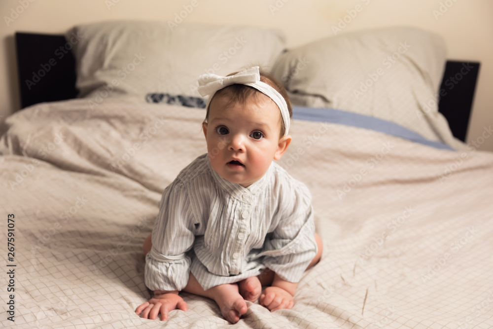 Cute newborn girl lying on the bed. The baby wants to sleep in the parent's bed. Cute newborn girl lying on the bed. The baby wants to sleep in the parent's bed.