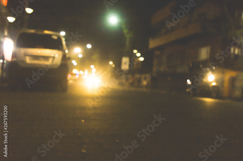 Kolkata City at foggy rainy night with motion blur effect. Car flares light effect realistic white glowing round headlight light beams. Soft focus. Shallow depth of field. Copy space room at front.