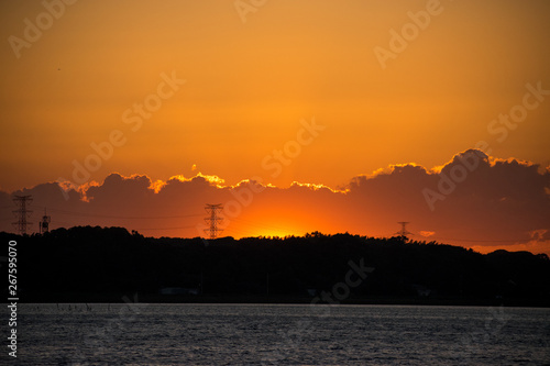 地平線の雲のかなたに沈む夕日の残照