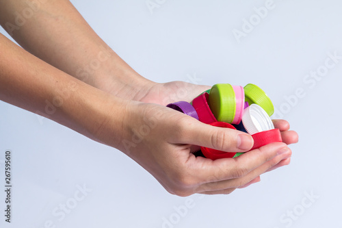 Girls holding plastic bottles caps for recycling to conserve the environment, on white background