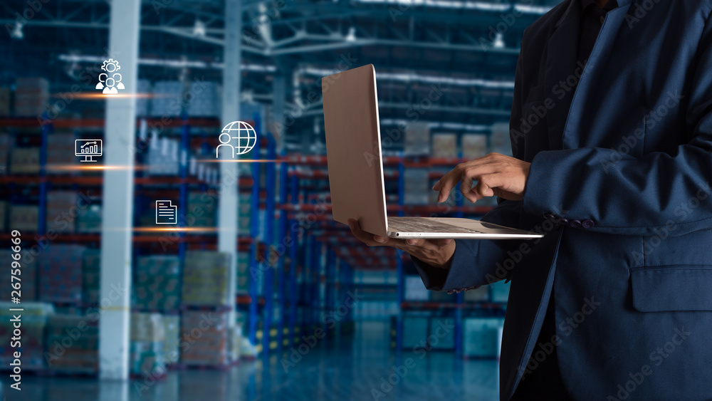 Businessman manager using laptop check orders online goods worldwide for network with Modern Trade warehouse logistics. Industry of logistics network concept. Businessman manager using laptop check orders online goods worldwide for network with Modern Trade warehouse logistics. Industry of logistics network concept.