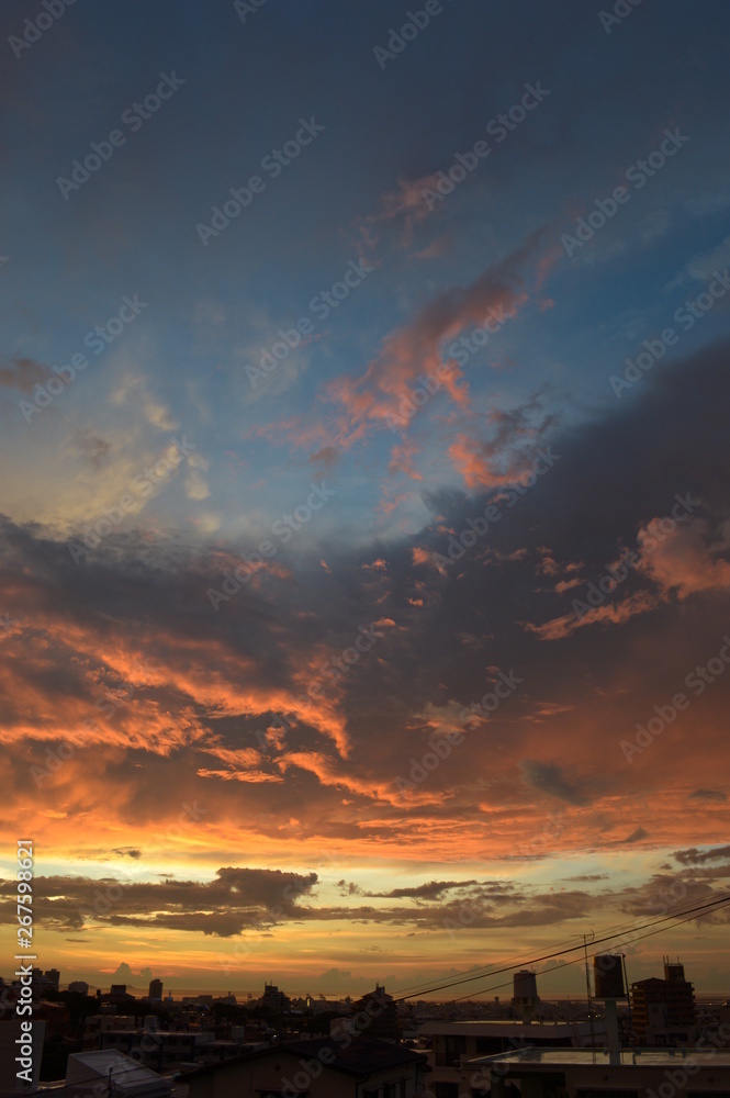 夕焼けに燃えるような雲と街のシルエット 夕焼けに燃えるような雲と街のシルエット