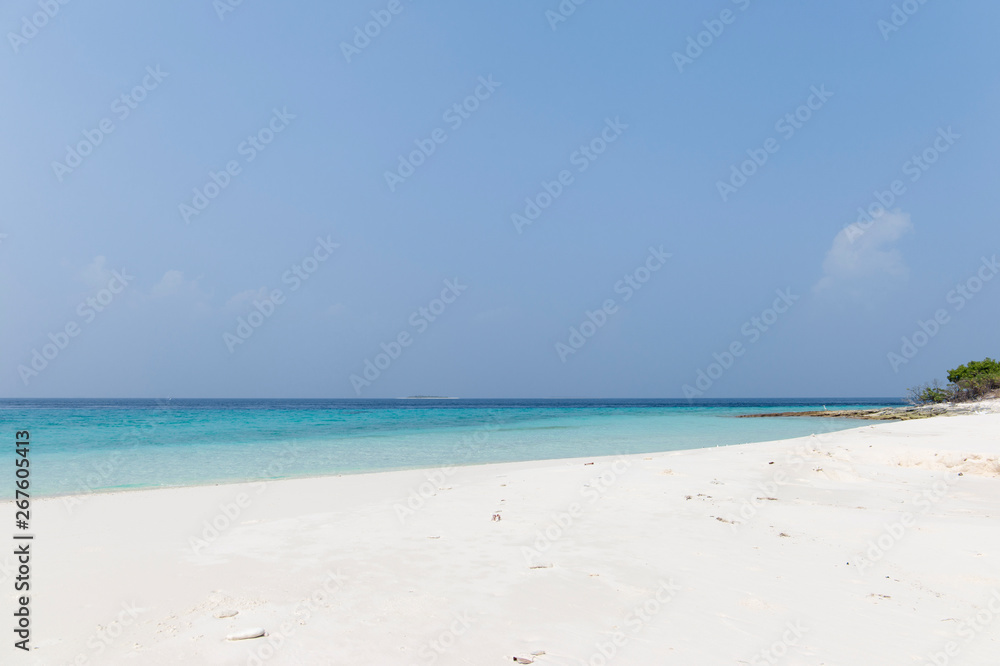 Small island in the Maldives surrounded by perfect crystal clear turquoise water