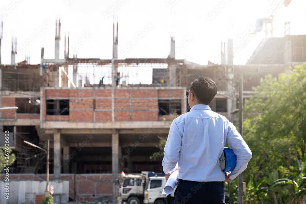 Architects And Engineer at a construction site looking at blueprints and pointing Architects And Engineer at a construction site looking at blueprints and pointing