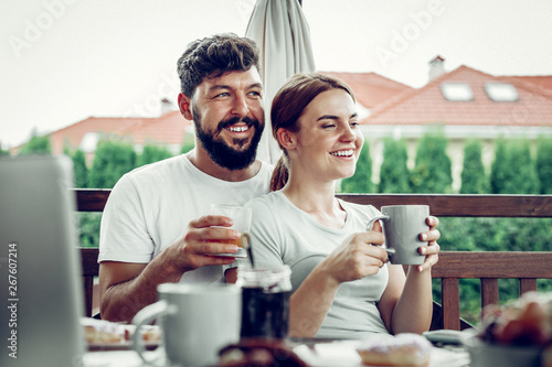 Happy husband embracing his spouse during breakfast in the garden.