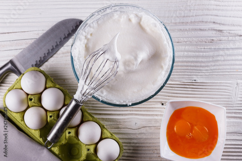 young woman in a gray aprons breaks the eggs