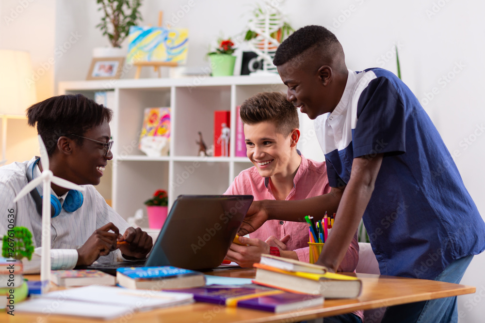 Students having good mood using laptop and having brainstorming Students having good mood using laptop and having brainstorming