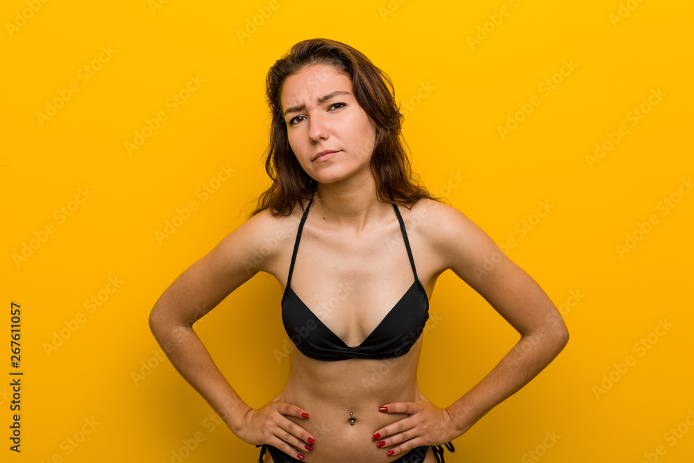 Young european woman wearing bikini scolding someone very angry.