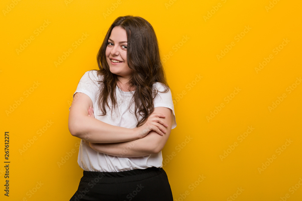 Obraz premium Young curvy plus size woman who feels confident, crossing arms with determination.